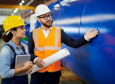 Waist up portrait of factory foreman doing quality inspection with female worker in workshop, copy space